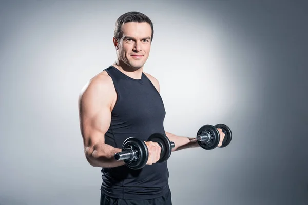 Entrenamiento Hombre Activo Con Mancuernas Sobre Fondo Gris — Foto de Stock