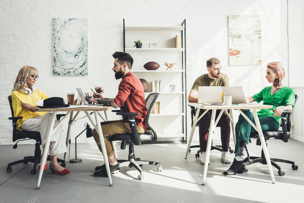 group of young creative workers working on project in office