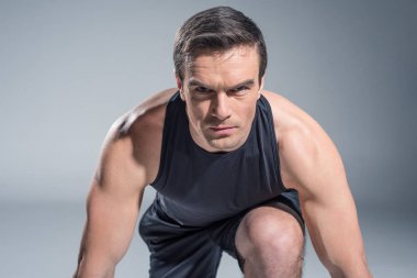 Kendine güvenen sporcu dışarı gri arka plan üzerinde çalışmaya hazır Başlarken