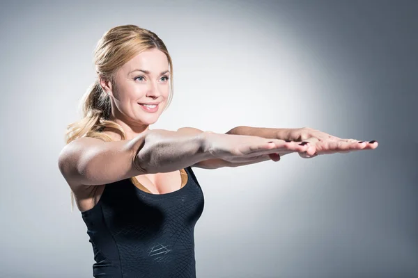 Atractiva Mujer Deportiva Con Las Manos Extendidas Sobre Fondo Gris —  Fotos de Stock