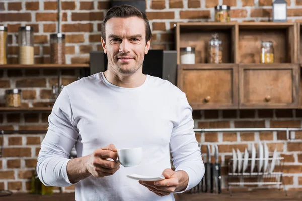 Homem Bonito Segurando Xícara Café Sorrindo Para Câmera Cozinha — Fotografia de Stock Grátis