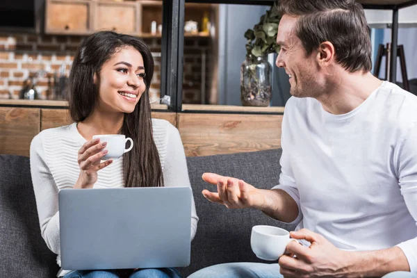 Multiethnic Couple Smiling Each Other Talking While Drinking Coffee Using — Stock Photo, Image