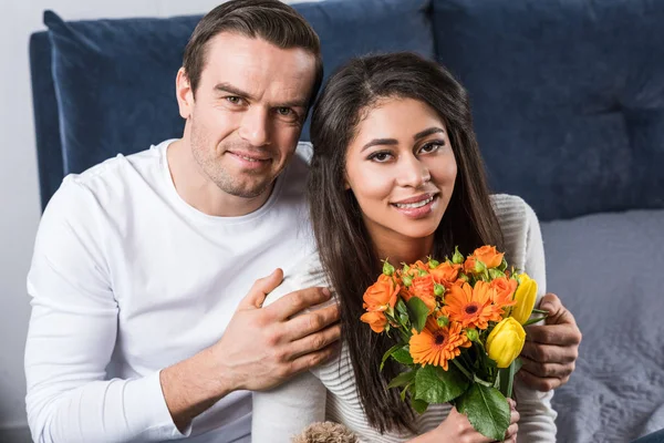 Jovem Feliz Abraçando Namorada Com Buquê Flores Sorrindo Para Câmera — Fotos gratuitas