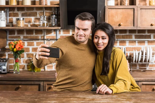 Happy Multiethnic Couple Taking Selfie Smartphone Kitchen — Free Stock Photo
