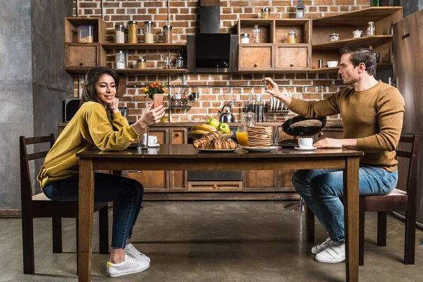 Seitenansicht Eines Multiethnischen Paares Das Beim Frühstück Smartphones Benutzt — kostenloses Stockfoto