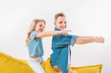 küçük çocuk sürüş ve sarı koltukta otururken işaret kardeş 