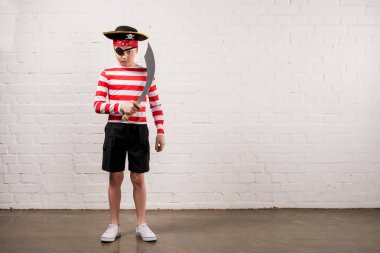 little boy pretending to be a pirate with toy knife clipart