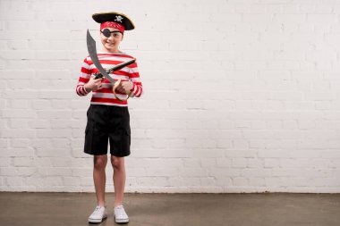little smiling boy with toy knife and gun in pirate costume  clipart