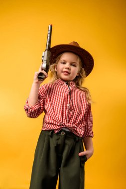 stylish cowgirl in hat with gun, isolated on yellow clipart