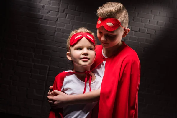 Hugging Siblings Superhero Costumes Red Masks — Stock Photo, Image