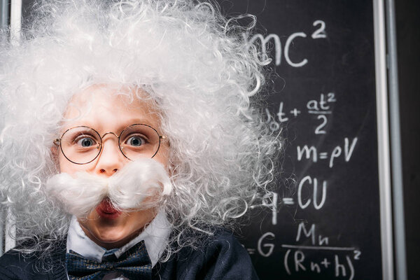 little Einstein in eyeglasses with theory of relativity on chalkboard