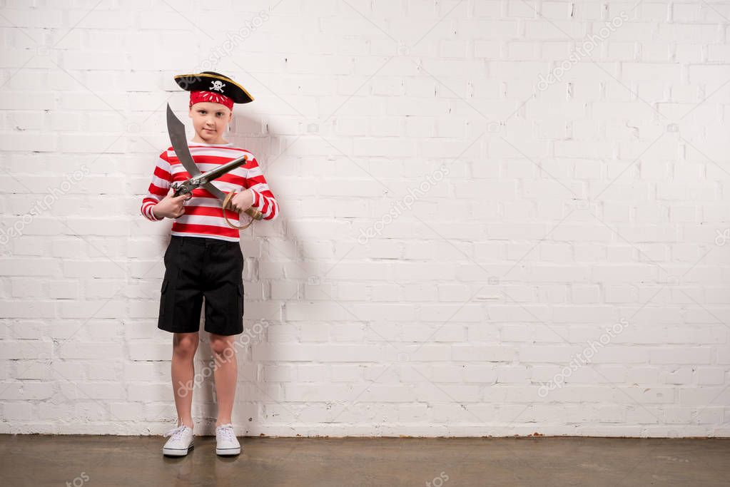 preteen boy with toy knife and gun in pirate costume for Halloween