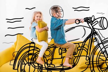 kız kardeşiyle sarı koltukta otururken bir motorcu ve sürme motosiklet gibi davranan çocuk