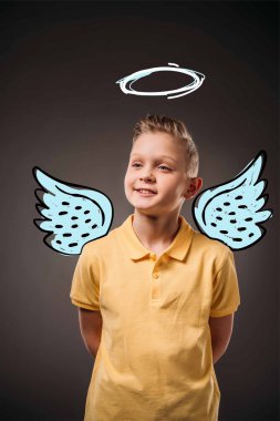 portrait of adorable preteen boy with drawn wings and nimbus as angel, isolated on grey clipart