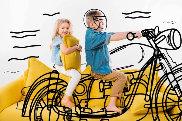 자전거 오토바이 여동생과 노란색 소파에 앉아있는 — 스톡 사진
