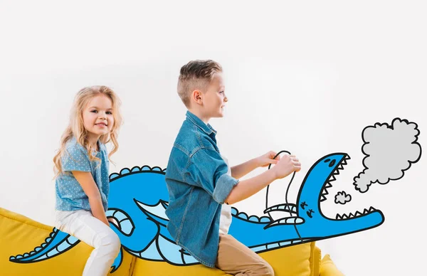Happy Siblings Riding Drawn Blue Dragon While Sitting Sofa — Stock Photo, Image
