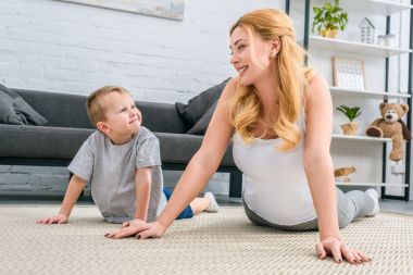 Mutlu anne ve oğlu pratik yoga modern oturma odasında 