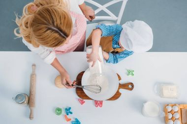 Anne ve çocuk süt yumurta ve un ile kase içine dökme Üstten Görünüm 