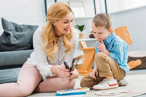 Leende Mor Visar Penslar Till Liten Pojke — Stockfoto