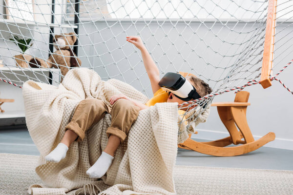 Child in boy hammock using virtual reality headset