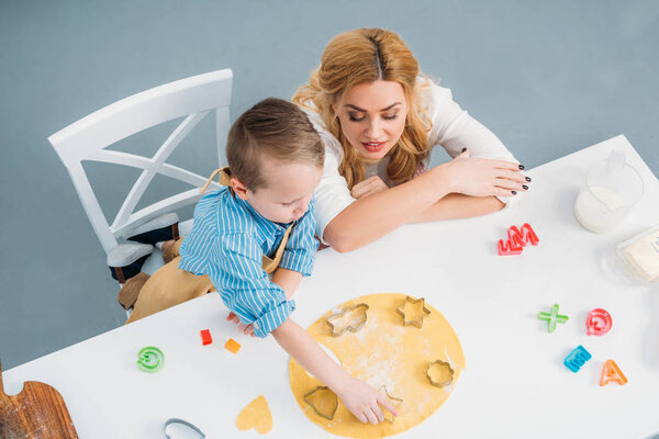 High angle view of mother and son using cooking molds 