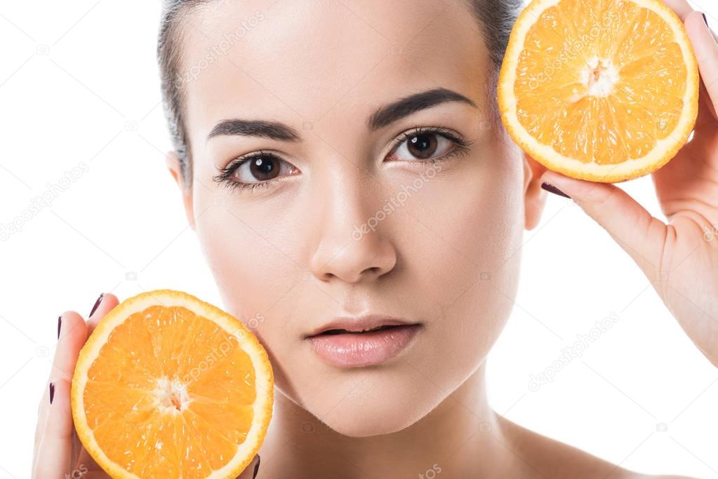 attractive naked girl with clean skin holding orange pieces isolated on white