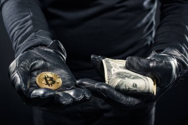 Yakın çekim görünümü bitcoin elinde, bir hırsız ve dolar