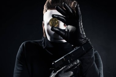 Hırsız beyaz maskeli holding silah ve altın bitcoin