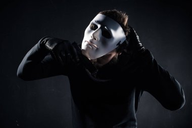Male criminal taking white mask off his face clipart