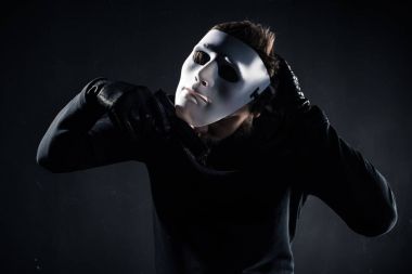 Male criminal taking white mask off his face clipart