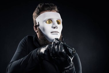 Maske ve bitcoins silahla nişan gözleri erkek suçlu