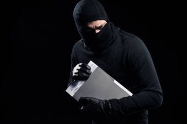 Burglar in balaclava holding top secret documents clipart