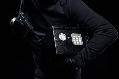 Close-up view of gun and locked safe in hands of thief clipart
