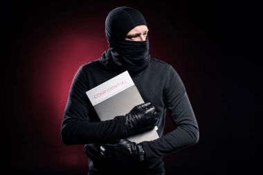 Criminal in balaclava holding confidential documents clipart