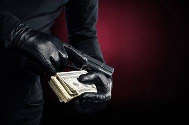 Silah ve soyguncu elinde dolar görünümünü kırpılmış