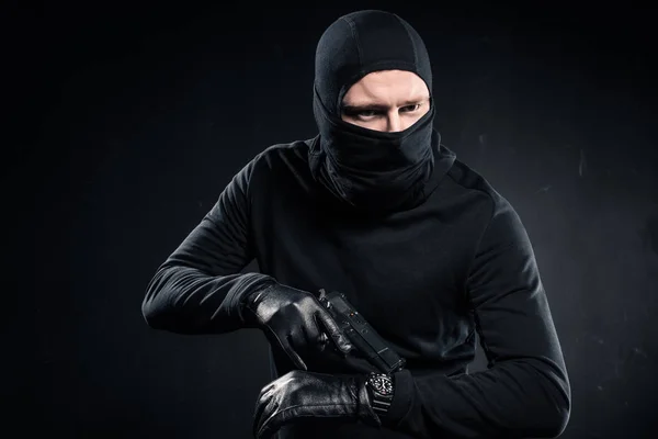 Hombre Criminal Guantes Con Pistola Revisando Reloj — Foto de stock gratis