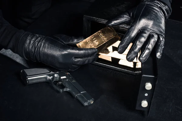 Крупный План Грабителя Пистолетом Забирающего Золотые Слитки Сейфа — стоковое фото