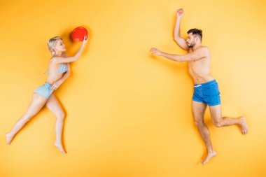 Genç yalınayak Çift disk sarı, yaz tatil kavramı üzerinde uçan ile oynarken Mayo içinde