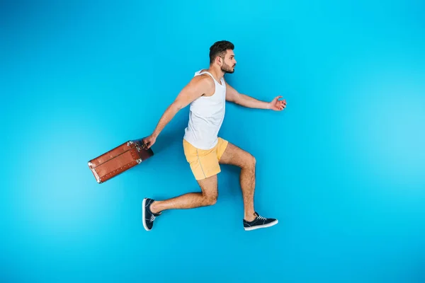 Full Length View Handsome Young Man Holding Suitcase Running Blue — Stock Photo, Image