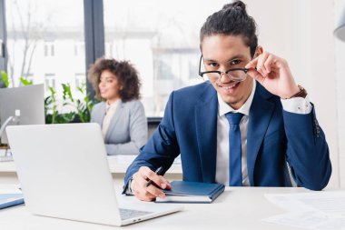 Dizüstü bilgisayarda Ofis Masası tarafından çalışma gözlük genç adam