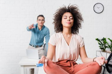 Rahatlatıcı ve erkek iş arkadaşınız ile ofiste meditasyon genç iş kadını