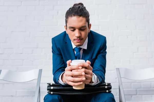 Hombre Afroamericano Traje Sentado Silla Esperando Con Taza Café Maletín — Foto de stock gratis