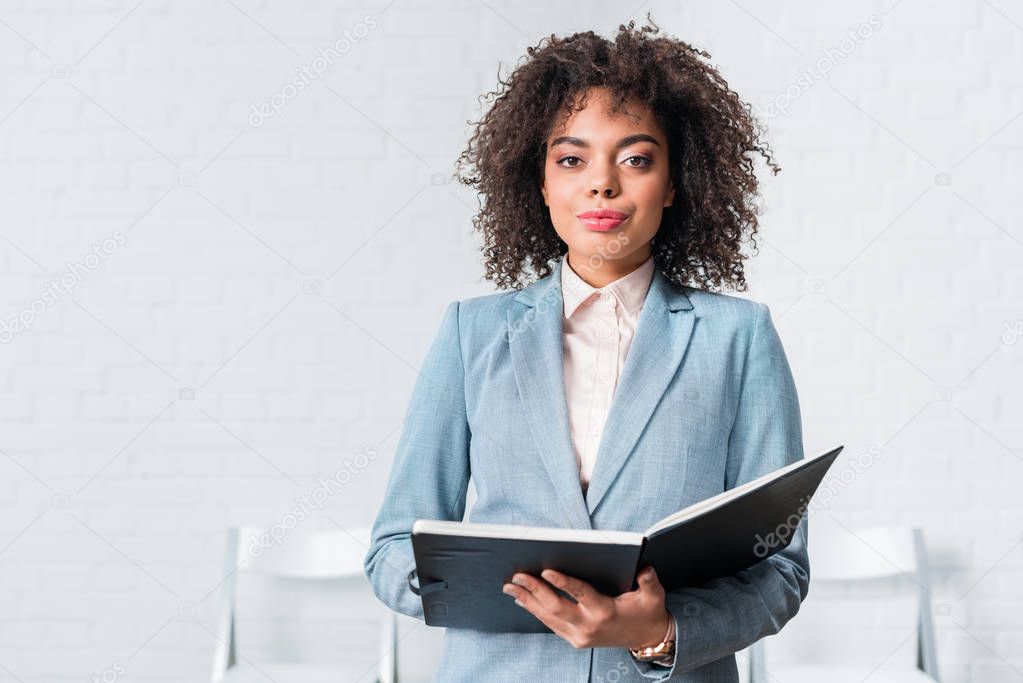 Confident African american businesswoman holding folder