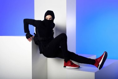 siyah giyim ayakta beyaz bloklar üzerinde mavi izole Ninja