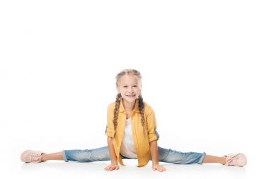 smiling little kid stretching, doing split and looking at camera isolated on white clipart