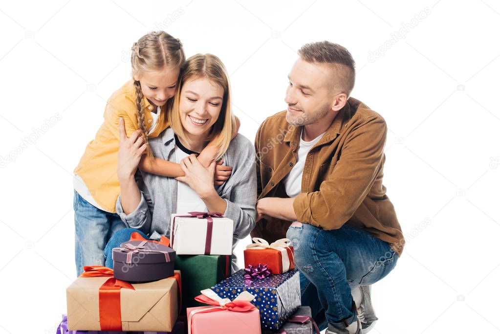 portrait of smiling family and pile of wrapped gifts isolated on white