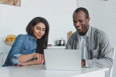 mutlu Afro-Amerikan kız ve erkek arkadaşı evde laptop arıyorum