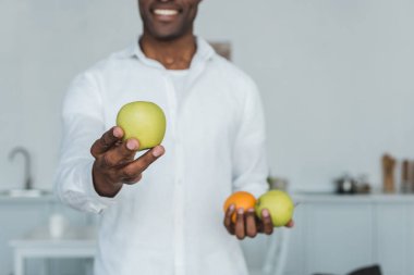 Afrika kökenli Amerikalı adam evde elma gösterilen görüntü kırpılmış