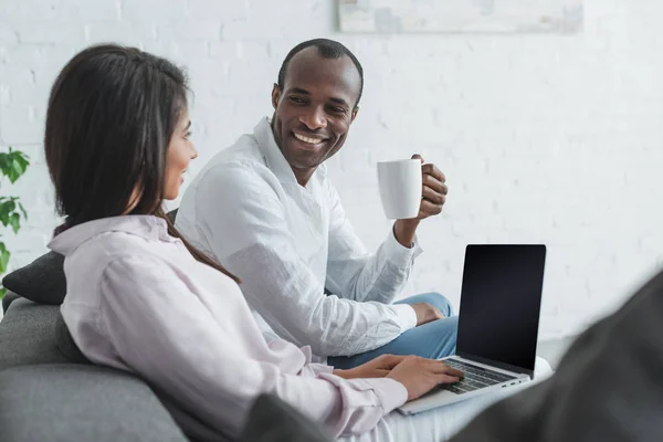 非洲裔美国人的女朋友使用膝上型电脑和男朋友在家喝咖啡 — 图库照片