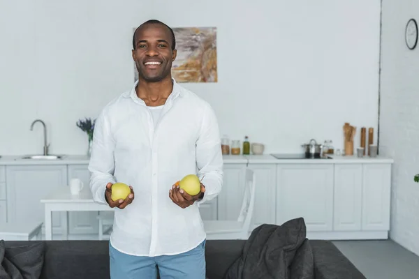 Usmívající Pohledný Americký Muž Který Držel Jablka Doma — Stock fotografie